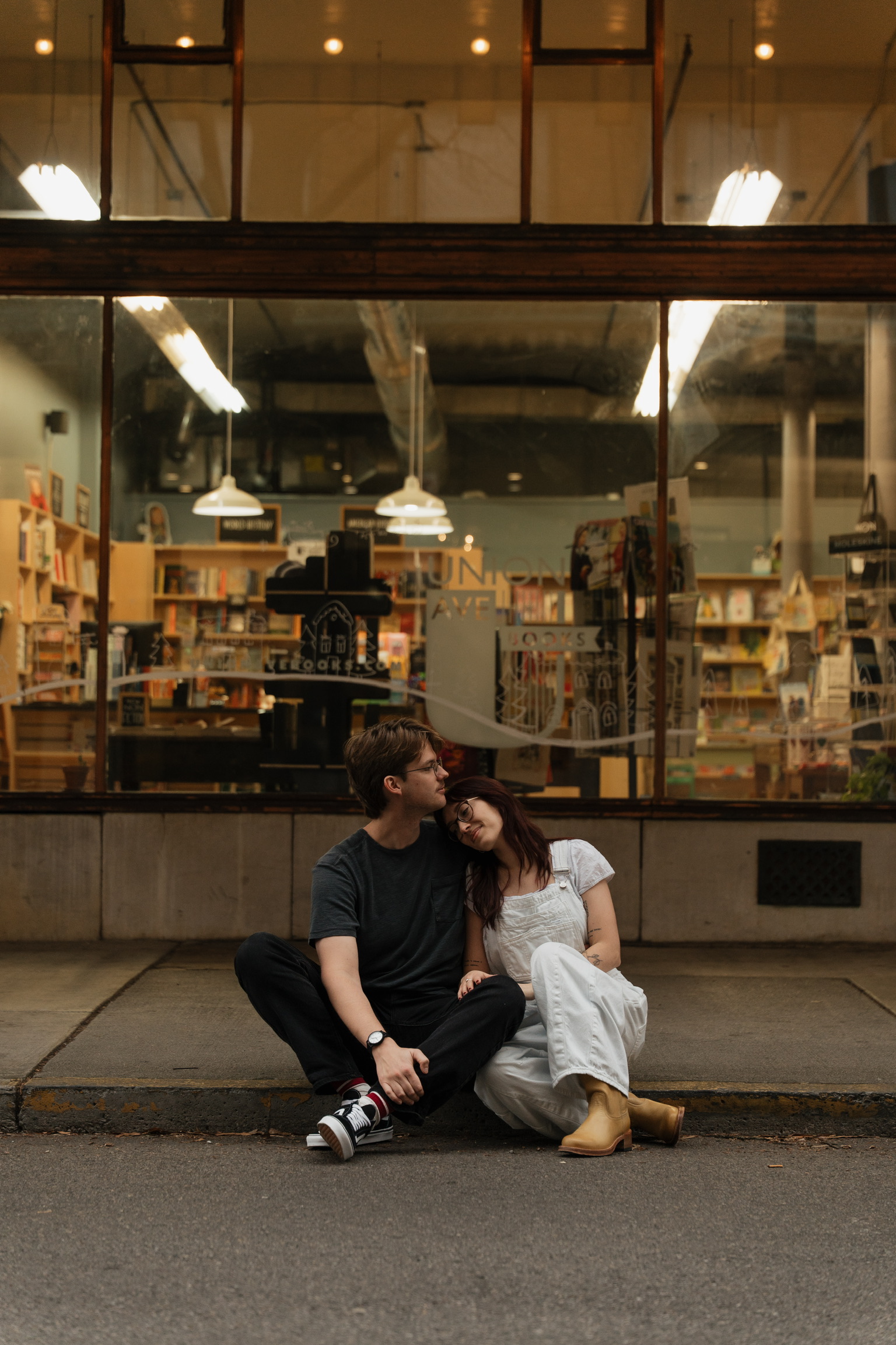 The bride and groom outside a store of books.