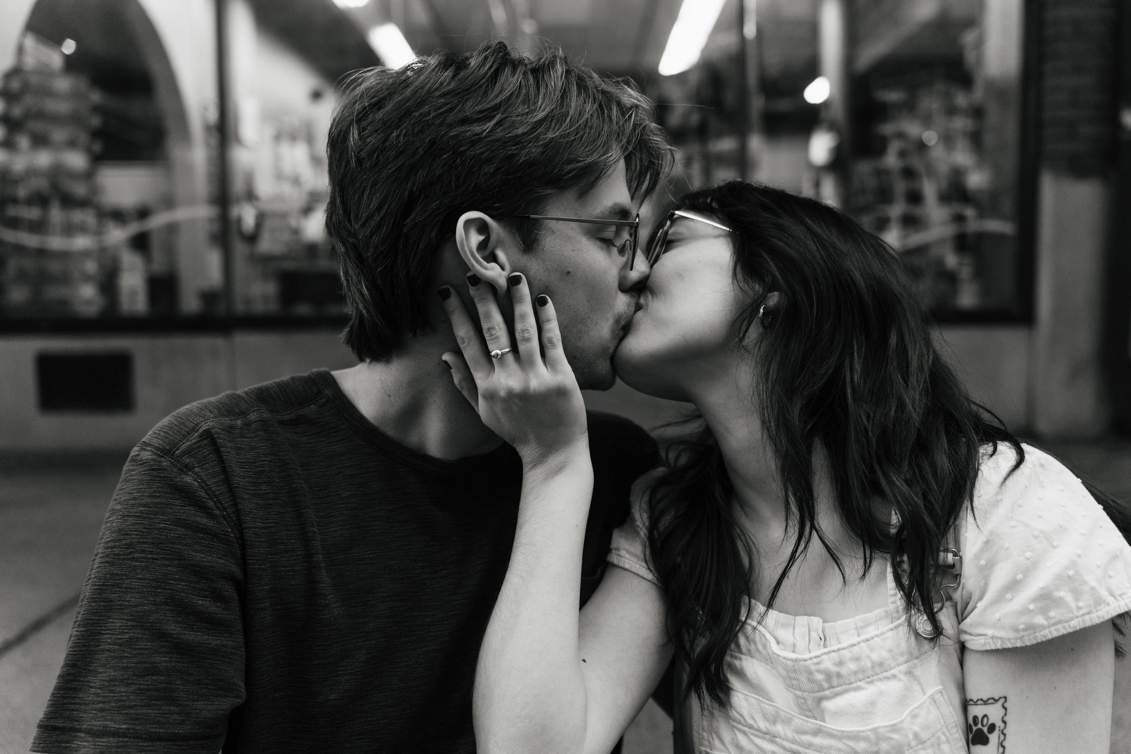 The bride and groom kiss in black and white.